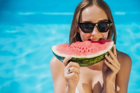 close-up-woman-eating-watermelon-pool_23-2148226281